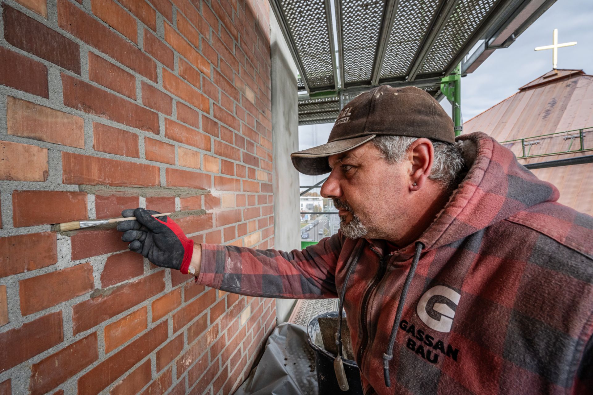 Maurer bei präziser Mauerwerksarbeit am Rohbau
