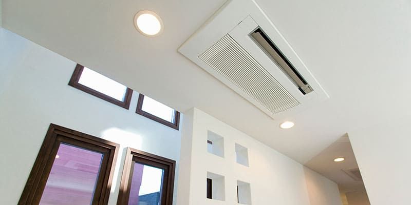 Pièce blanche moderne avec éclairage encastré, fenêtres de toit et ventilation au plafond