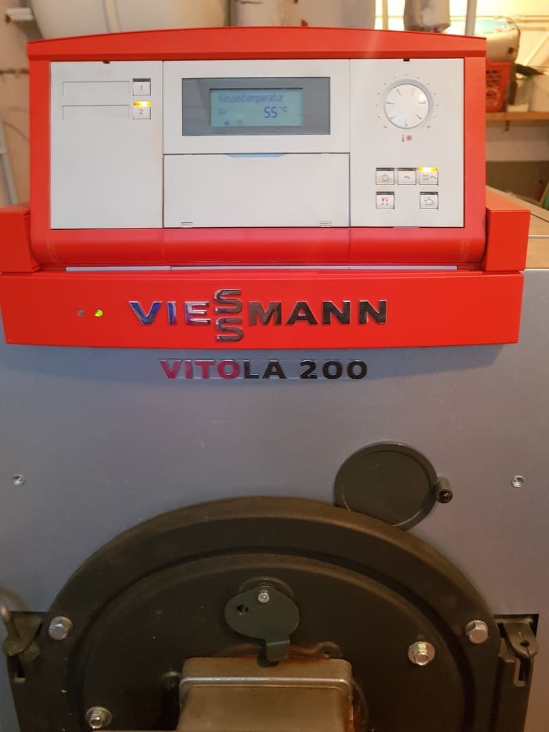 Panneau de commande de la chaudière Viessmann Vitola 200 avec affichage et porte de brûleur ronde en dessous