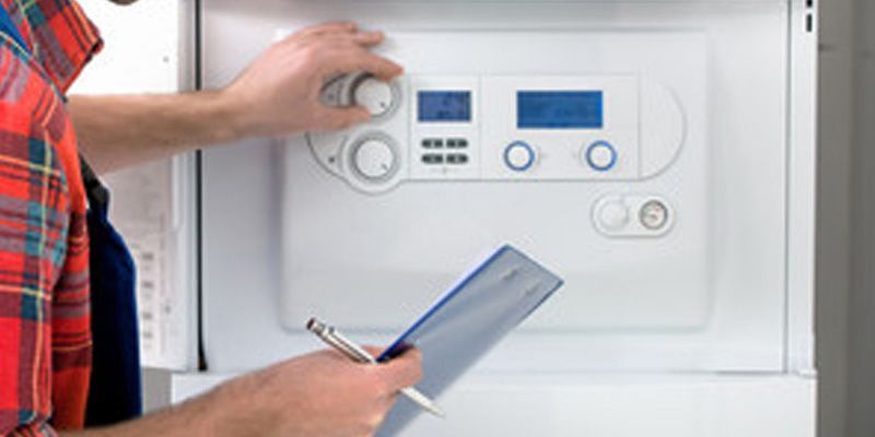 Réglage manuel d'un panneau de commande domotique tout en tenant un bloc-notes à côté d'une armoire électrique ouverte