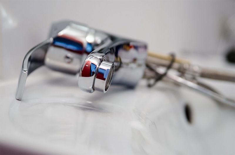Robinet chromé au-dessus d'un évier blanc