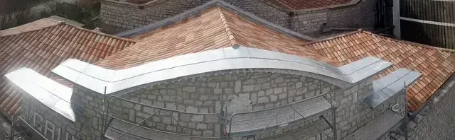 Toiture en tuiles canal et façade d'édifice en pierre