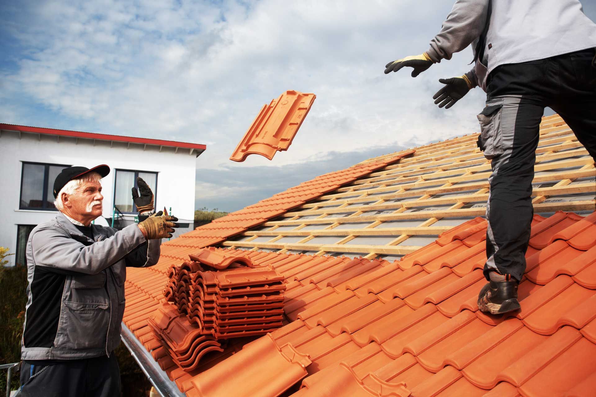 Couvreurs au travail se passant des tuiles