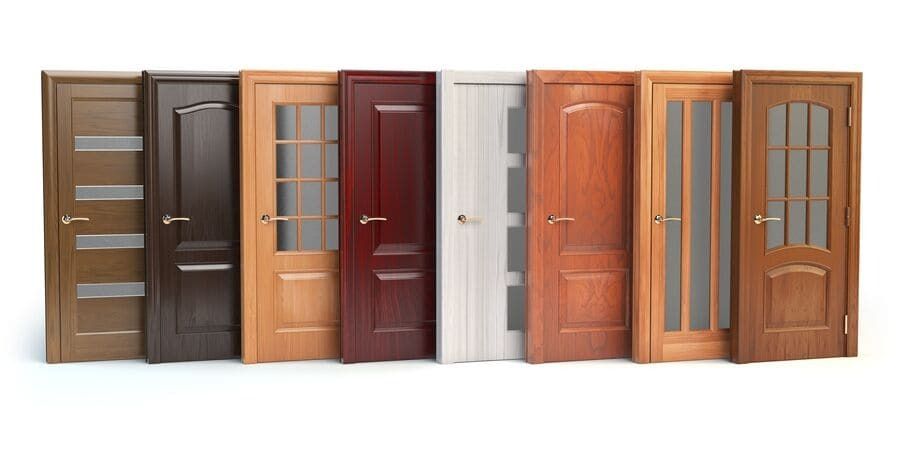 Varias puertas de entrada de madera en tonos marrones, grises, blancos y rojos, expuestas una al lado de la otra.