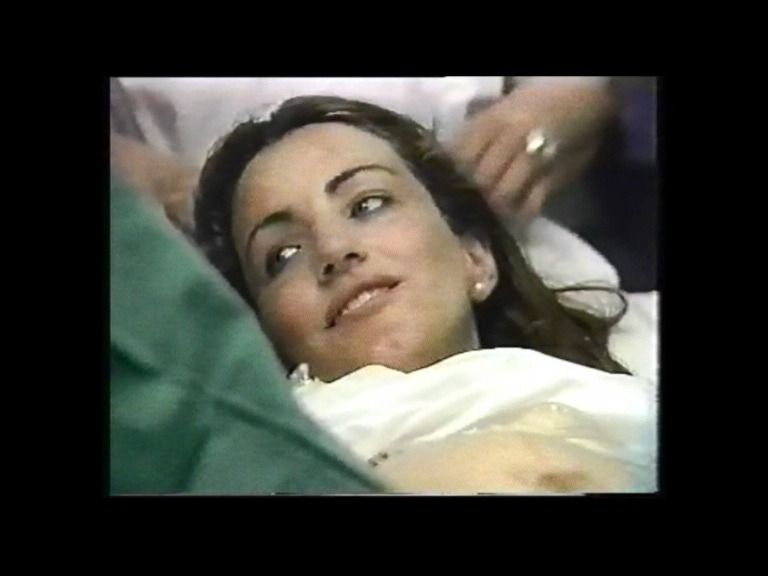 Mujer acostada en una cama de hospital, aparentemente sometida a un procedimiento médico.