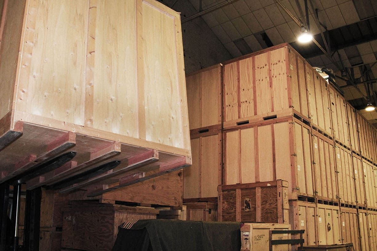 De grandes caisses en bois empilées dans un entrepôt ou un lieu de stockage.