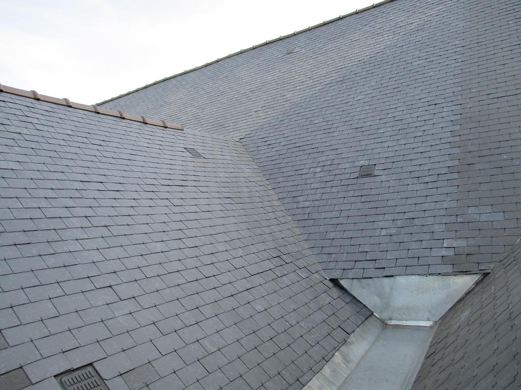 Toiture en ardoise avec gouttière métallique.