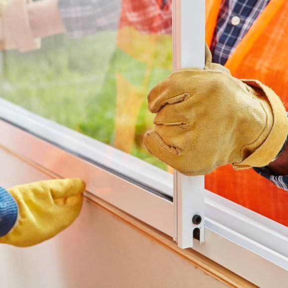 Personen bauen ein Fenster ein