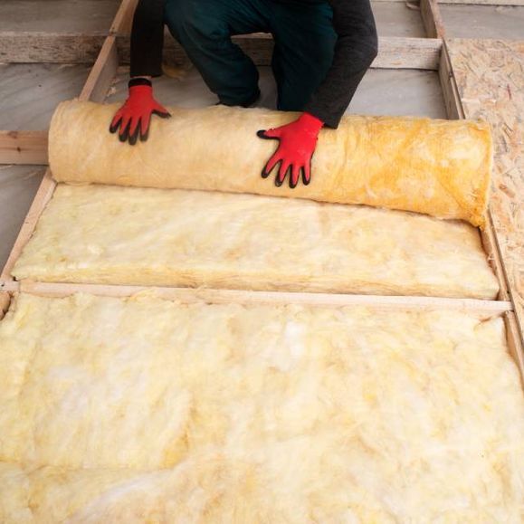 Person arbeitet an der Wärmedämmung eines Dachs