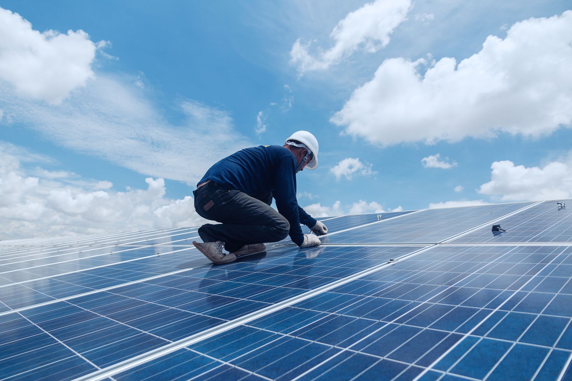 Un monsieur entretient des panneaux photovoltaïques