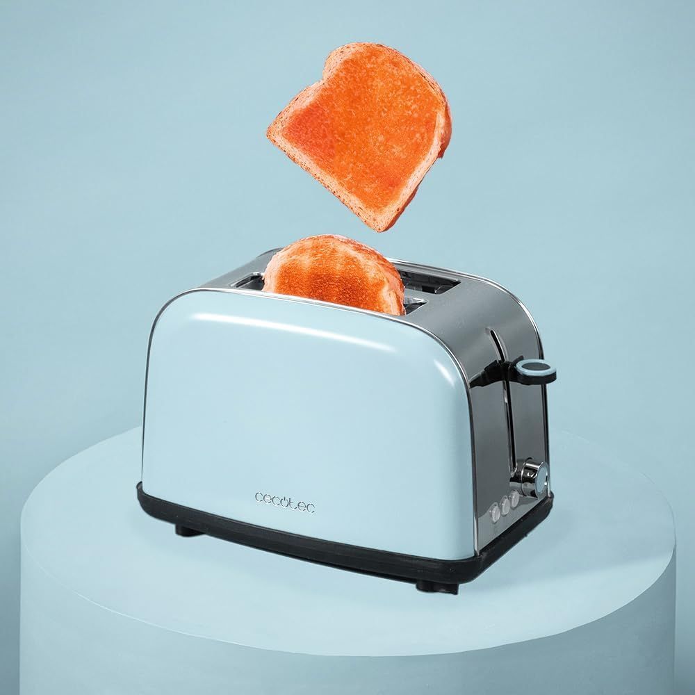 Mujer trabajando con una laptop, escribiendo en una mesa. Cabello oscuro, ropa neutra y una taza de café cerca.