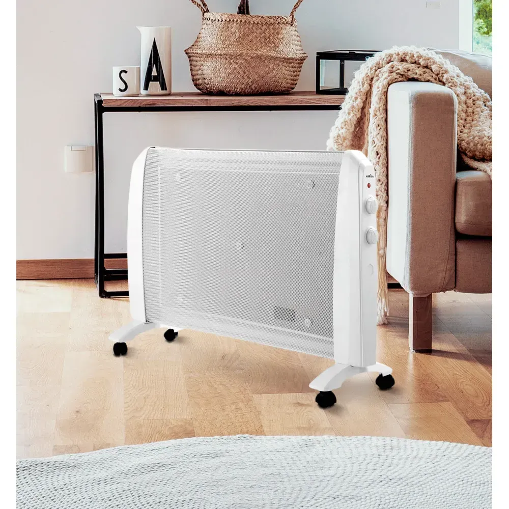 Un hombre con barba sonríe mientras escribe en una computadora en una oficina.