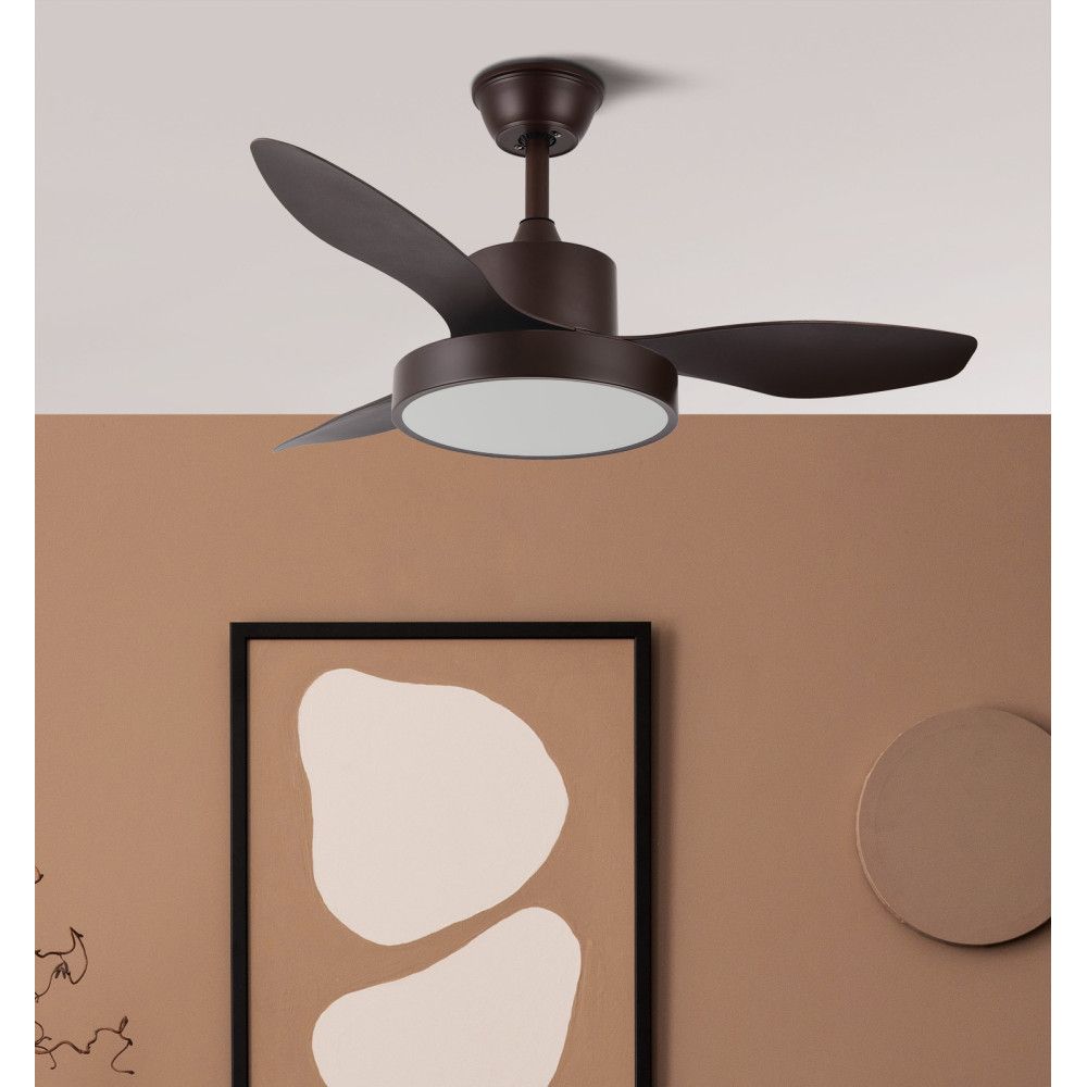 Mujer trabajando con una laptop, escribiendo en una mesa. Cabello oscuro, ropa neutra y una taza de café cerca.