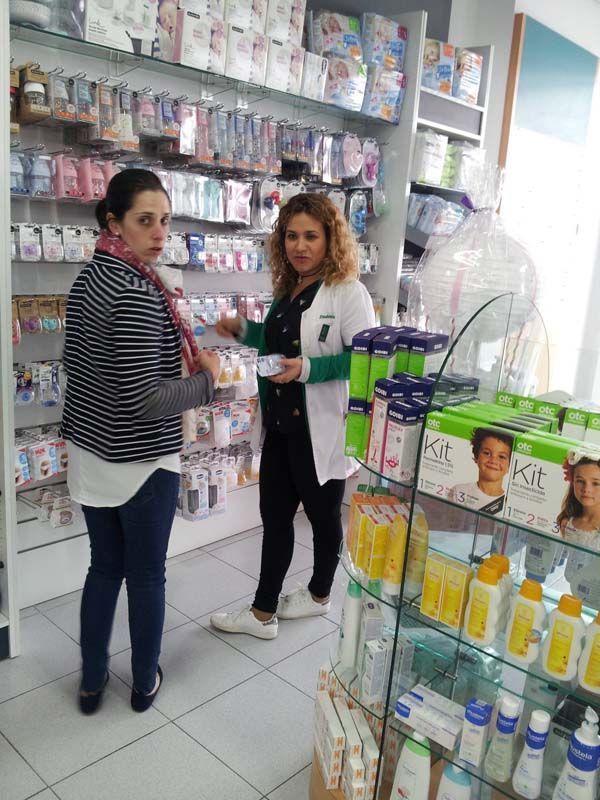 Dos mujeres están paradas en una tienda hablando entre sí.