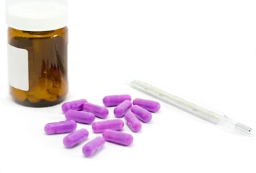 Una botella de pastillas de color morado y una pipeta sobre un fondo blanco.