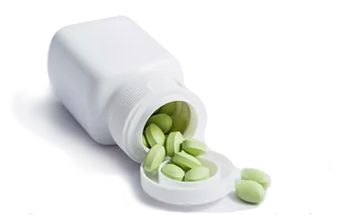 Las pastillas verdes salen a raudales de una botella blanca.