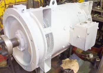 Gran motor eléctrico industrial blanco con un eje saliente en un entorno de taller