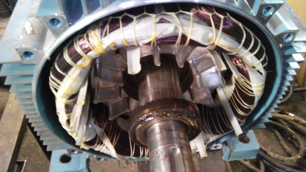 Primer plano del estator de un motor eléctrico con los bobinados de cobre expuestos y el eje central del rotor