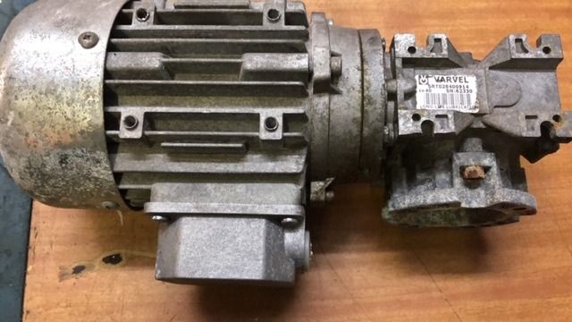 Motor industrial usado con caja de engranajes acoplada sobre una mesa de madera