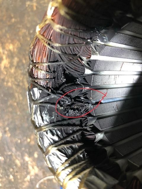 Primer plano de un globo de foil negro dañado, con un desgarro y el material interior a la vista.