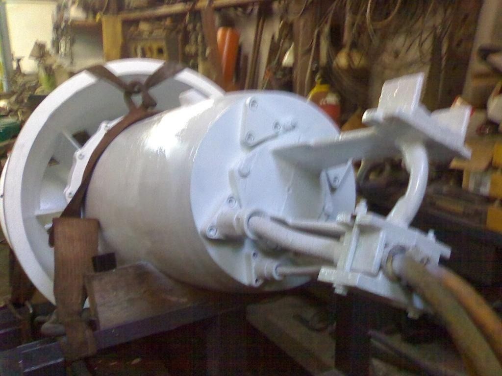 Gran recipiente industrial blanco a presión, con tuberías y mangueras, en un taller