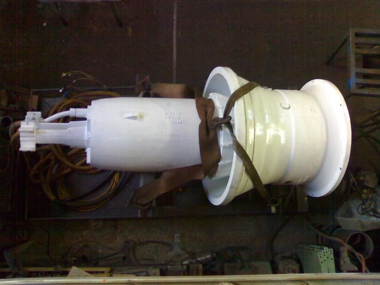 Un gran cohete o misil blanco en un hangar industrial poco iluminado, sujeto a una cuna de soporte
