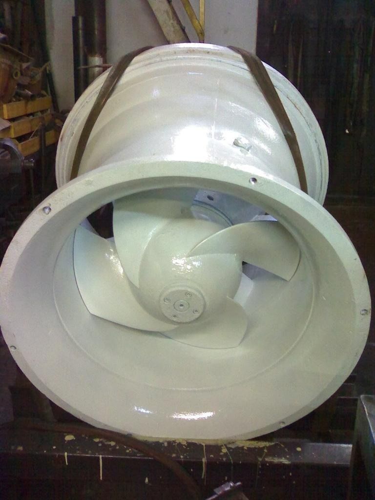 Carcasa blanca de ventilador o turbina por conductos, con una gran abertura circular, vista de frente en un entorno industrial
