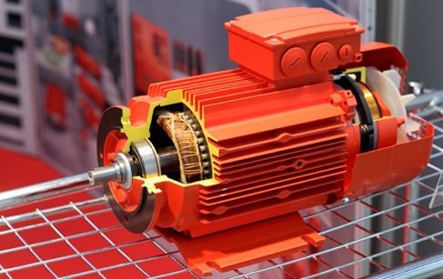 Motor eléctrico industrial naranja montado en una estructura metálica, mostrado en primer plano con los engranajes y el eje al descubierto