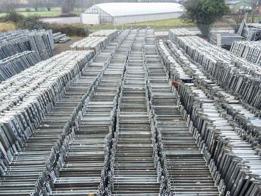 Reihen von im Freien gestapelten Metallgerüstrahmen.