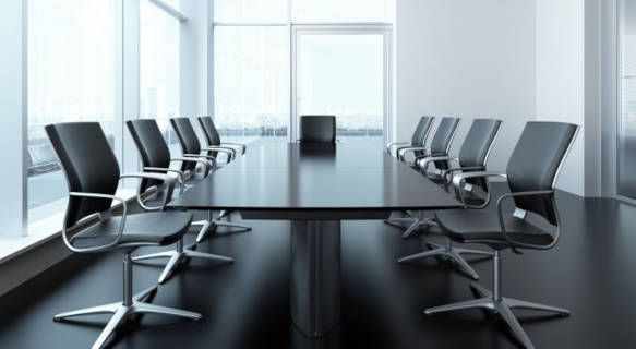Una sala de conferencias con una mesa larga y sillas