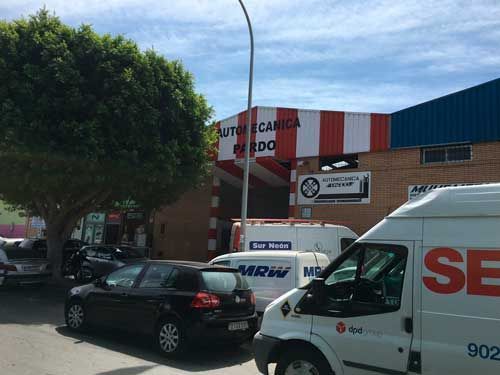 Una camioneta blanca con la palabra se está estacionada frente a un edificio.