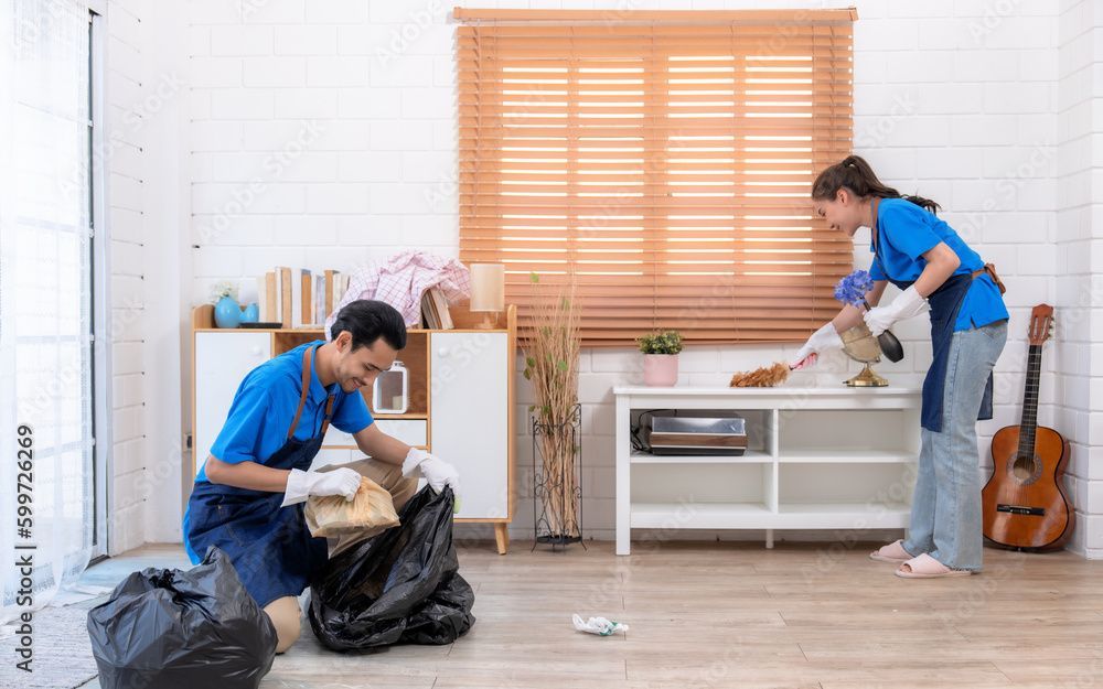 Deux déménageurs en chemises bleues déballent et disposent des meubles dans une pièce lumineuse