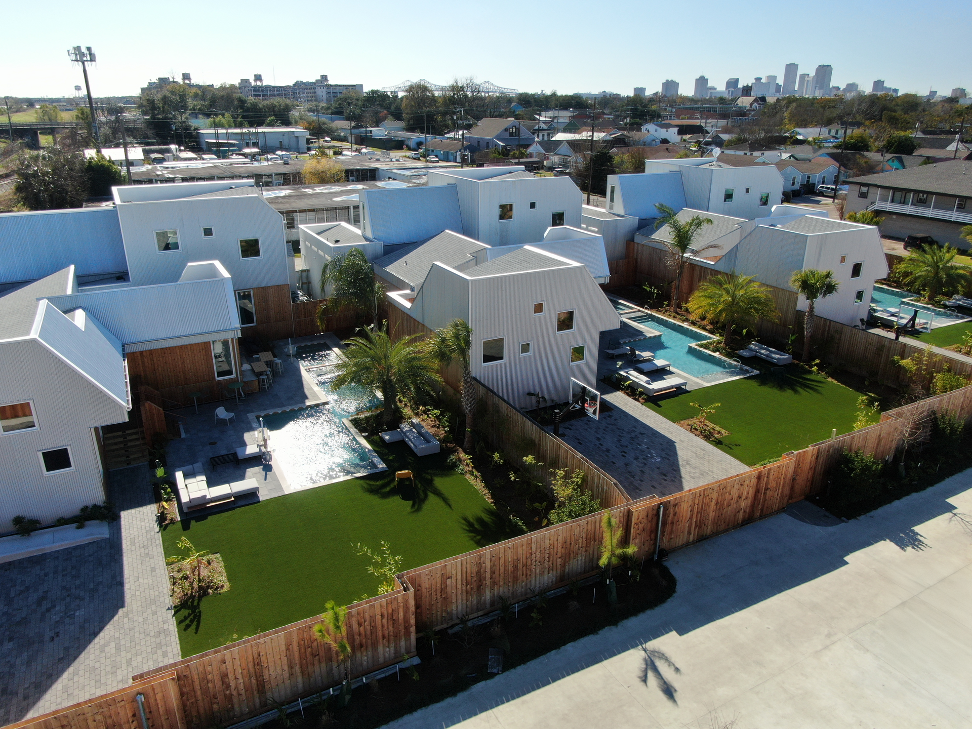 An aerial view of a residential area with white houses and a pool