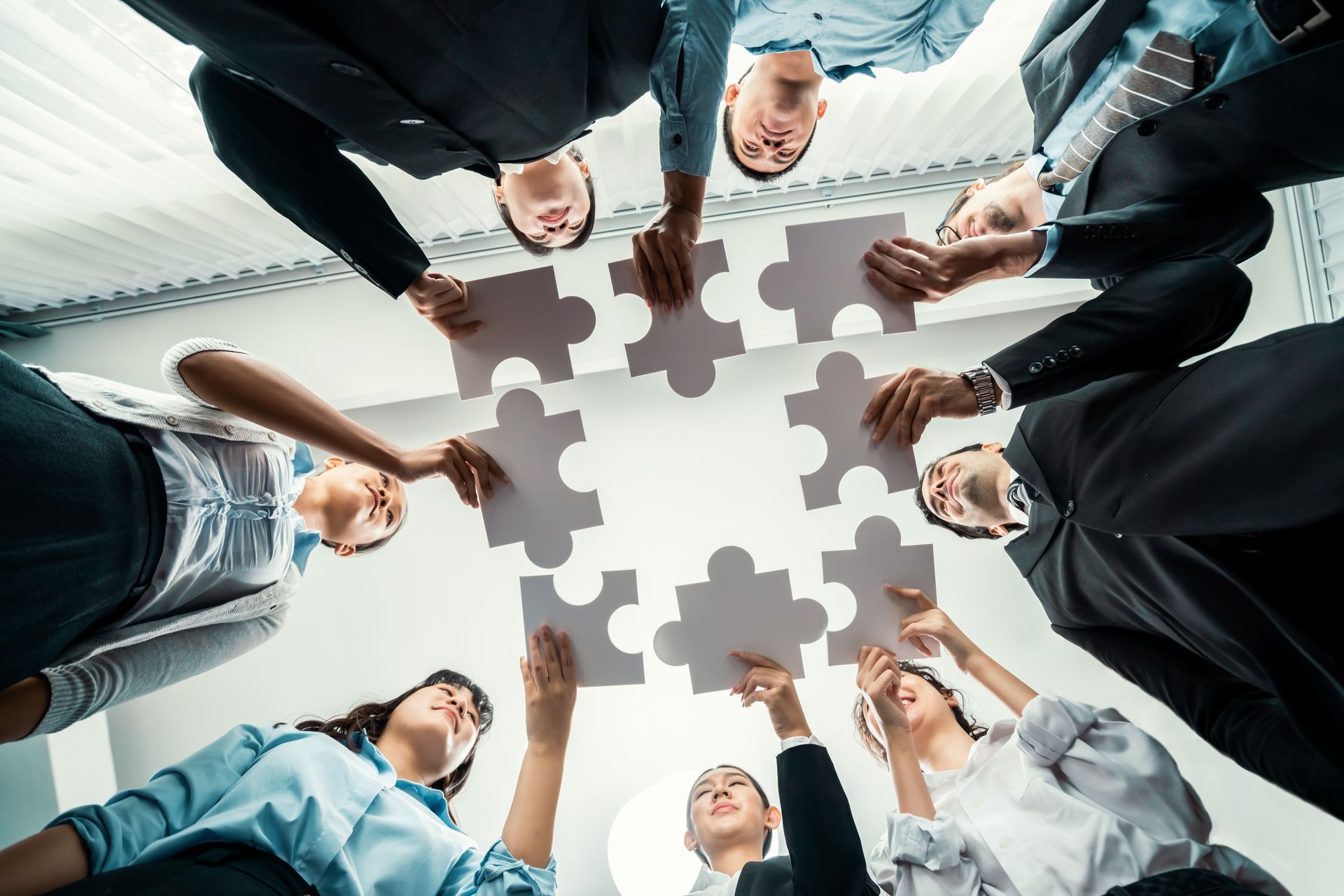Plusieurs personnes face à face tenant une pièce de puzzle.