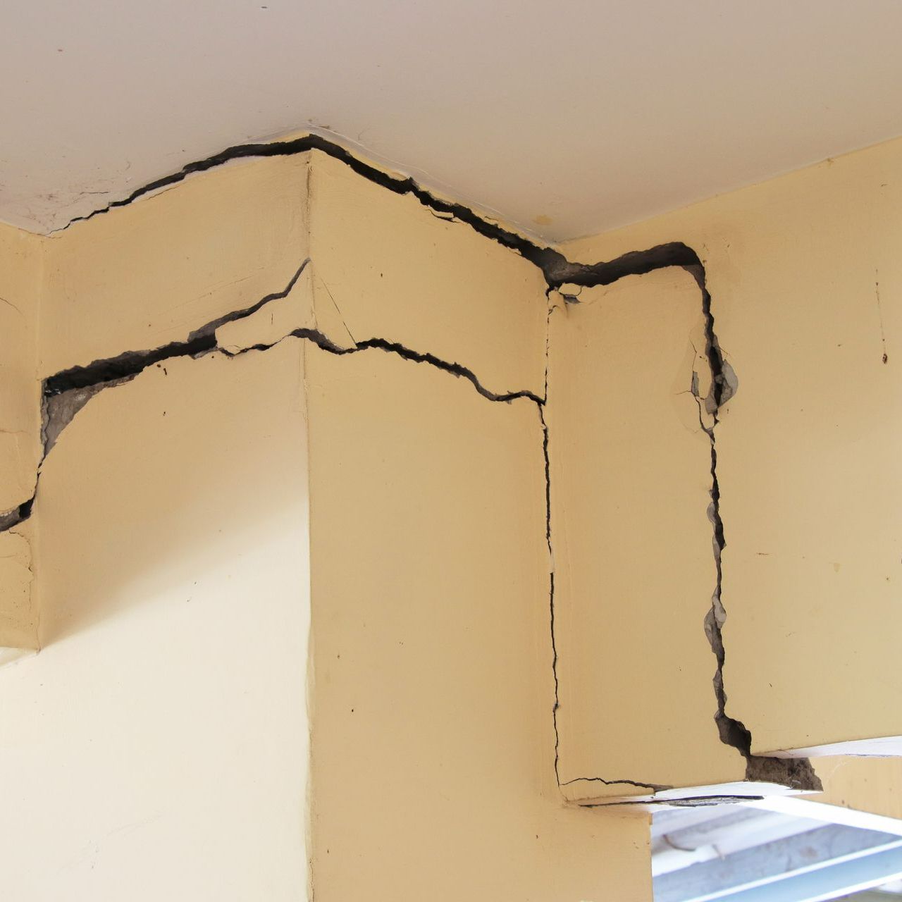 Des fissures en haut des murs intérieurs d'une maison.
