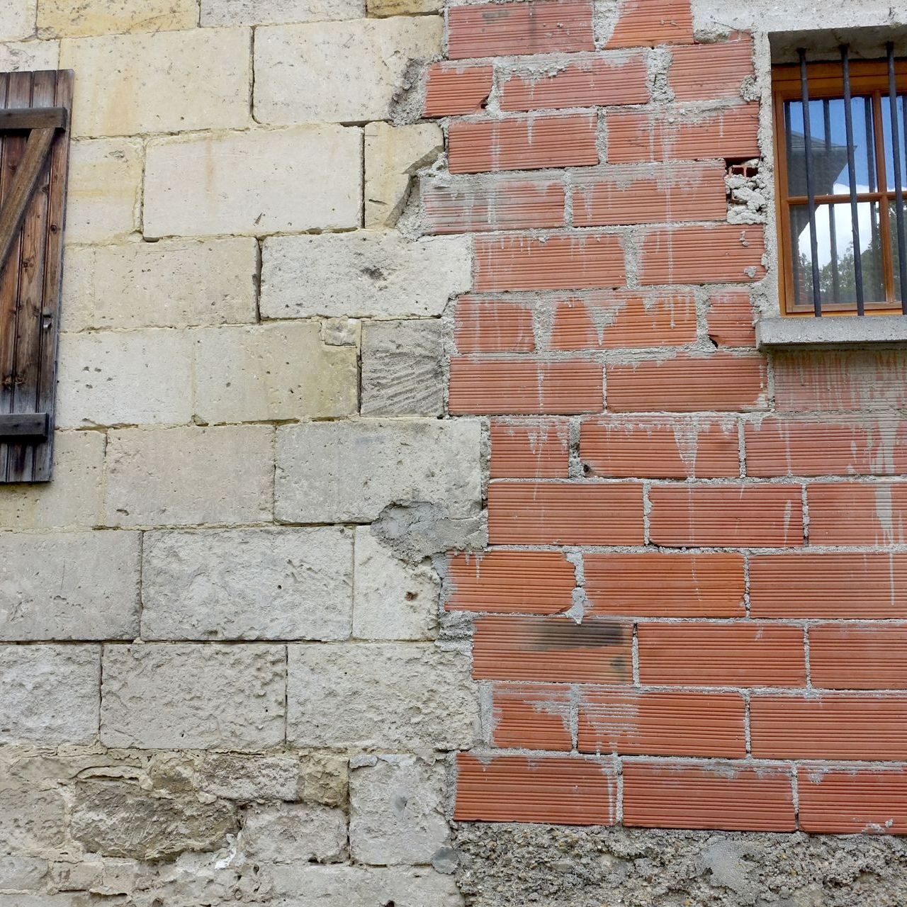 Mur extérieur d'une maison en pierre et en brique.
