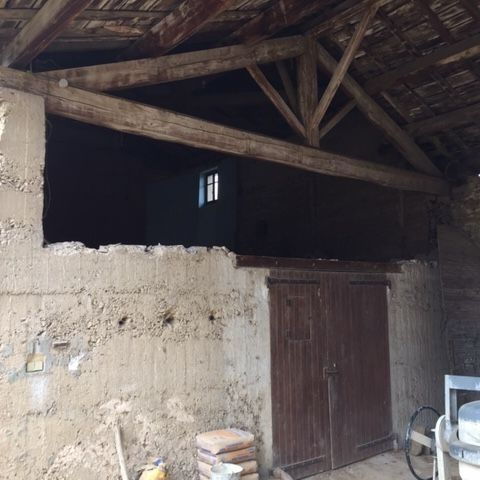 Mur de grange dont la moitié supérieure a été enlevée.
