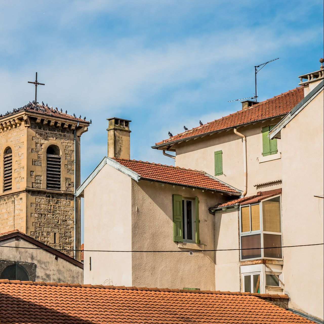 Maison aux volets de couleur verte près d'une église.