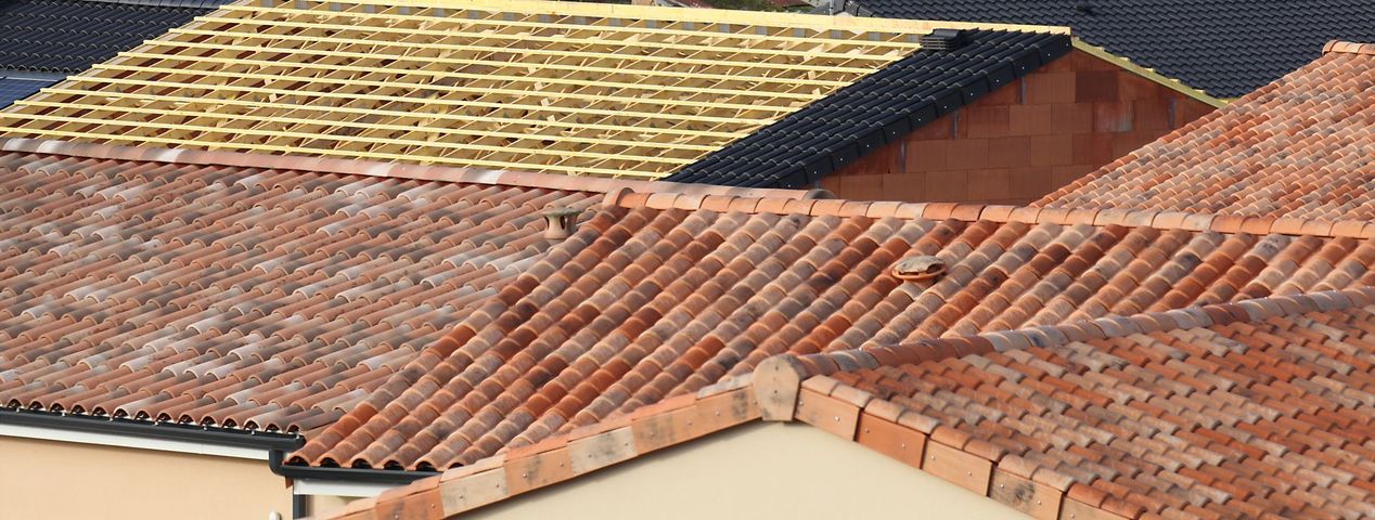 Toits de tuiles en terre cuite rouges et jaunes vus du ciel.
