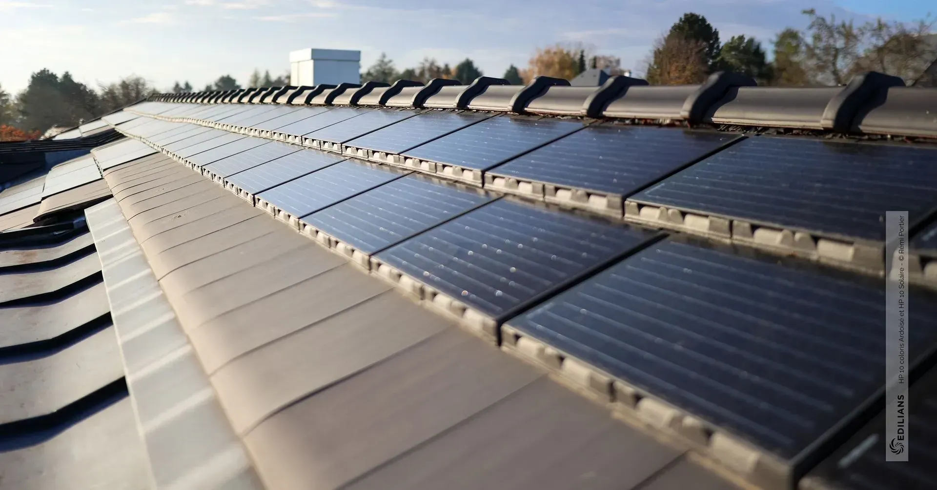 Des panneaux solaires installés sur un toit en pente sous un ciel dégagé.