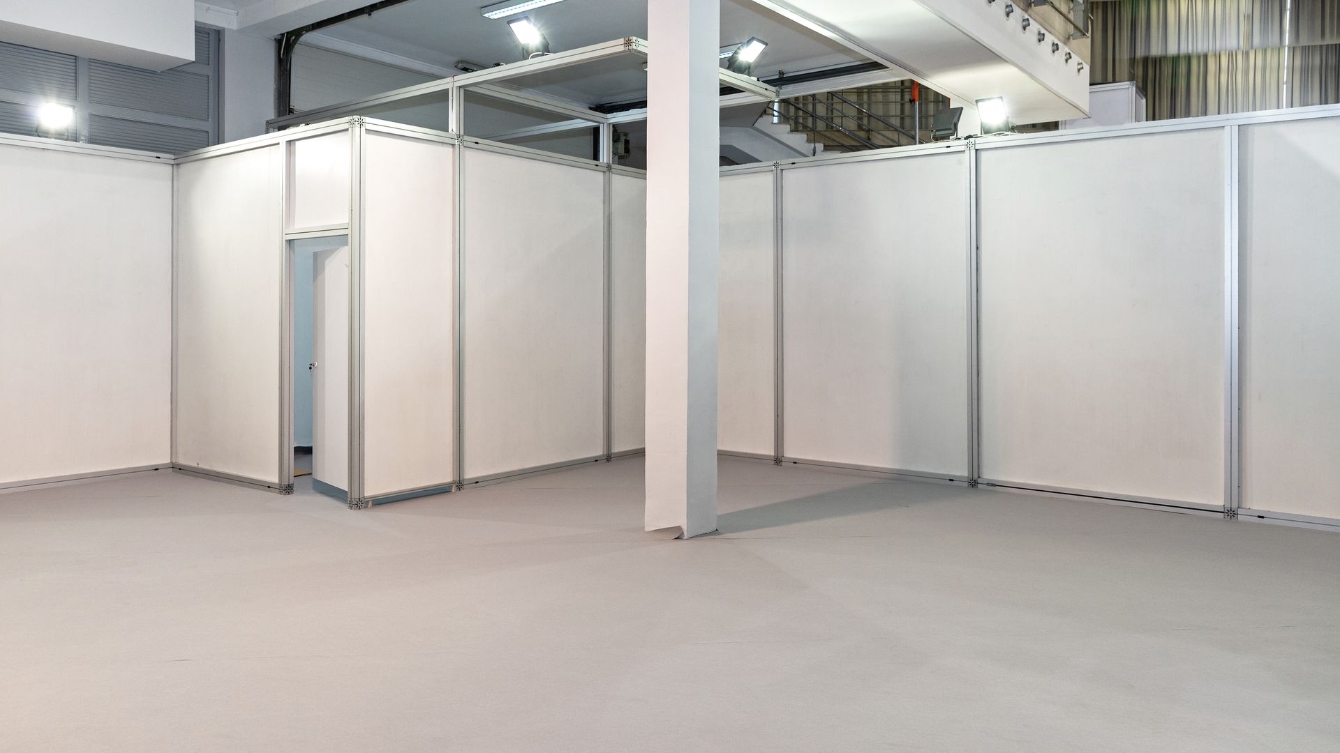Une pièce vide entourée de cloisons blanches.