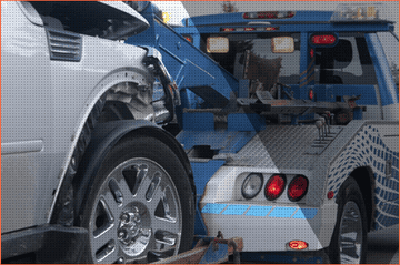 Un automóvil blanco dañado siendo remolcado por una grúa azul después de un accidente.