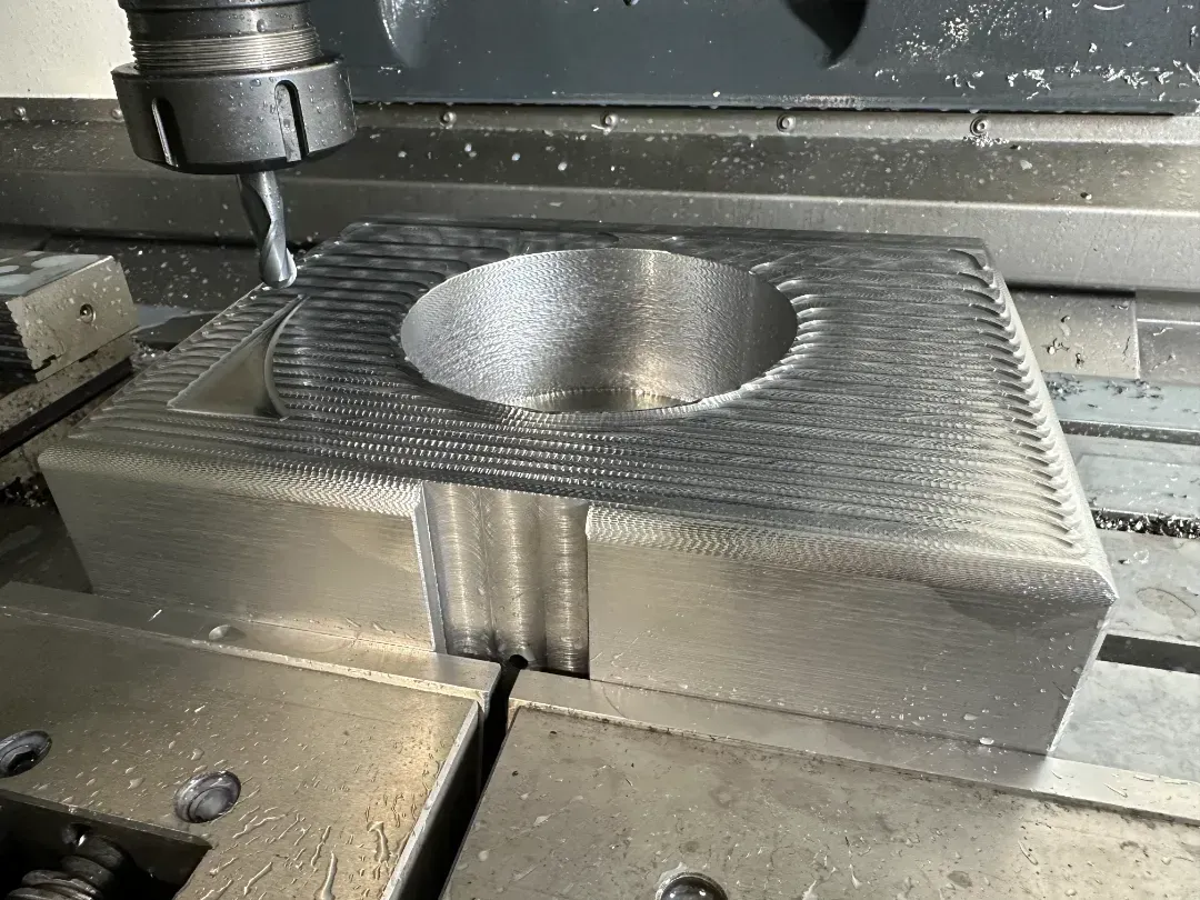 Una máquina está cortando un trozo de metal con un agujero en él.