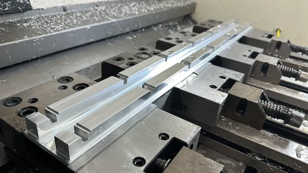 Una máquina está cortando un trozo de metal sobre una mesa.