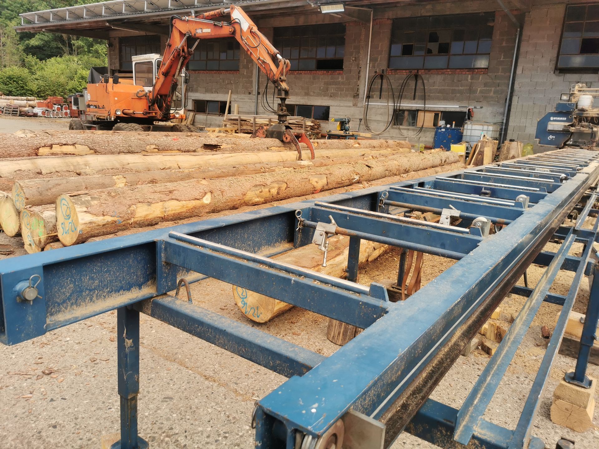 Mitarbeiter von Tribale Günter Mobiles Sägewerk bearbeitet Holz