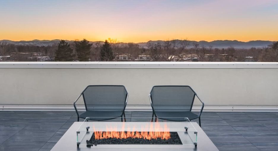 Outdoor concrete sports court with basketball hoop and volleyball net; lush green grass surrounds.