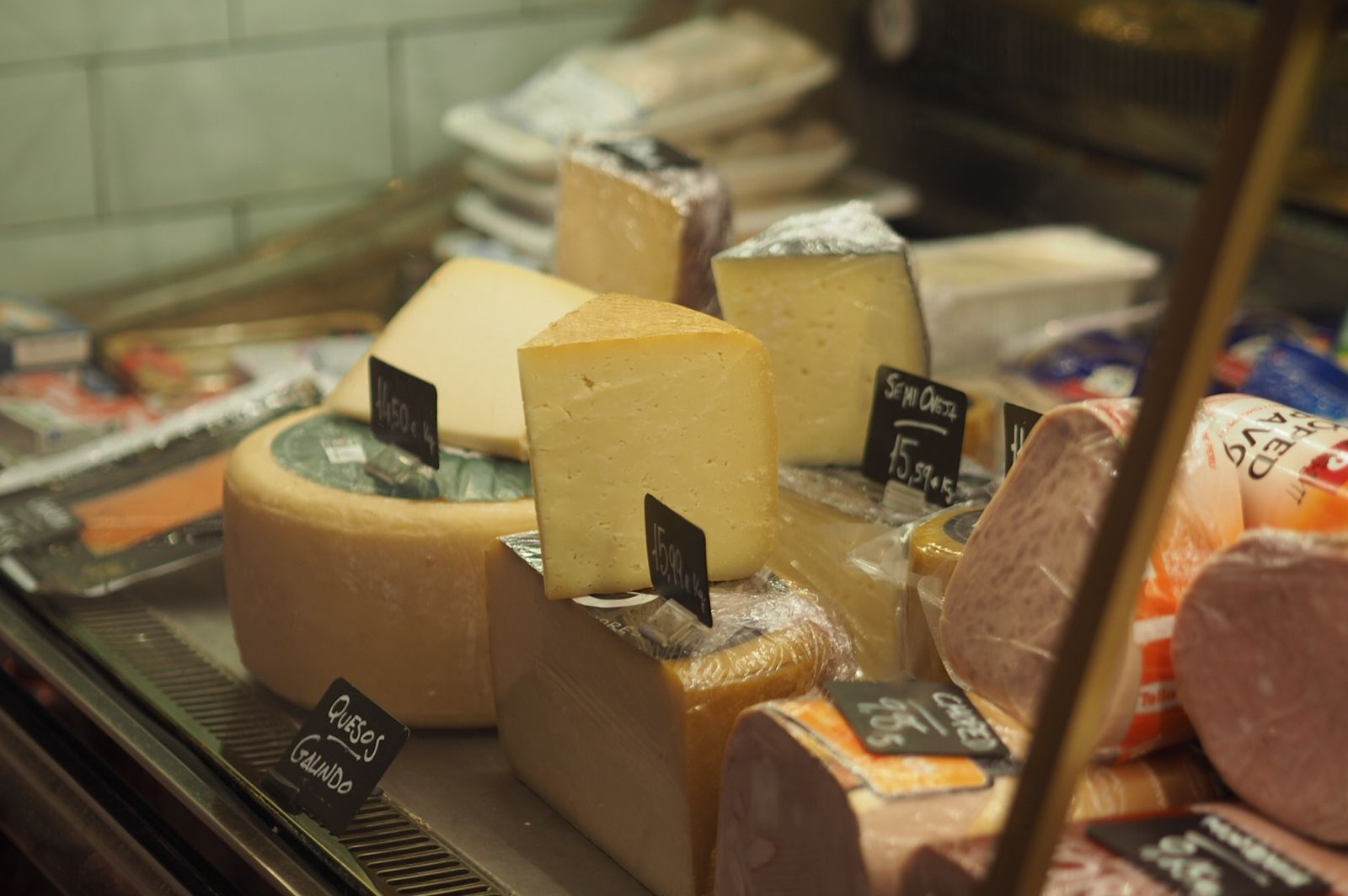 Una vitrina llena de una variedad de quesos y carnes.