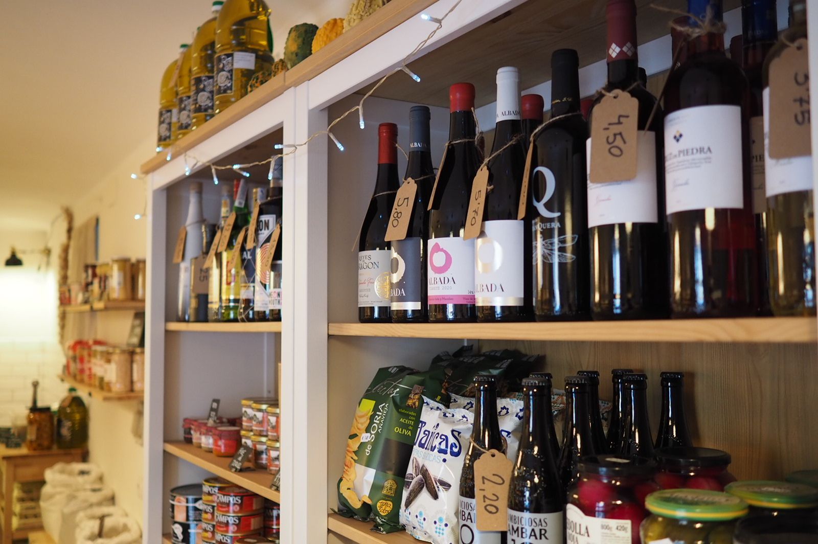 Un estante lleno de botellas de vino y otros alimentos.