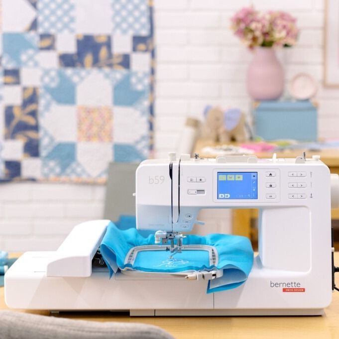 Una máquina de coser blanca con la tapa abierta sobre un fondo blanco.