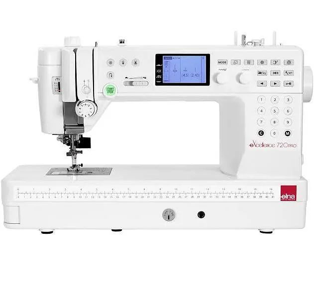 Una máquina de coser blanca está sobre una mesa blanca.